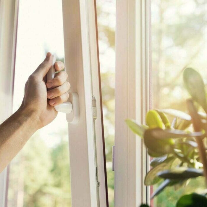 Asunnon viilennys Käsi avaa ikkunaa ja auringonvalo tulvii sisään.